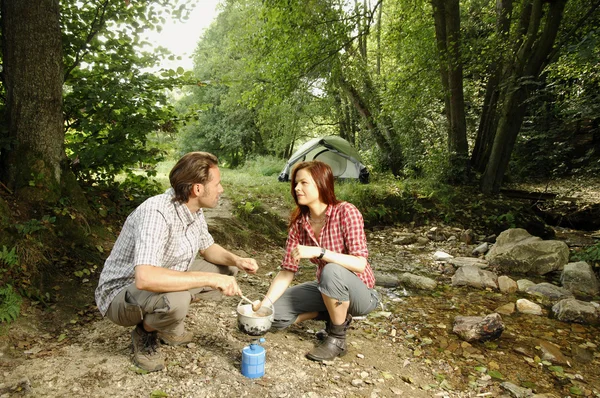 Casal preparando comida ao ar livre - série de acampamento — Fotografia de Stock
