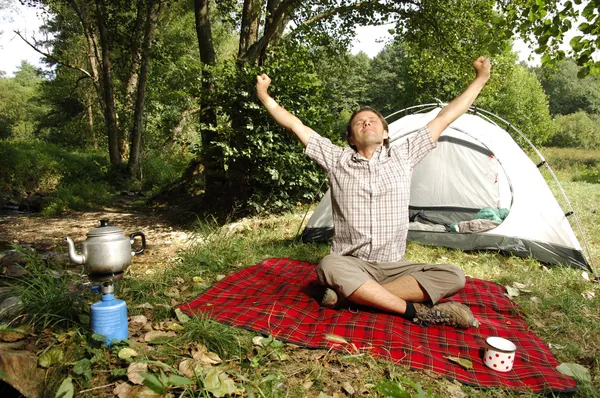 Homme s'étirant devant une tente - série camping Photos De Stock Libres De Droits