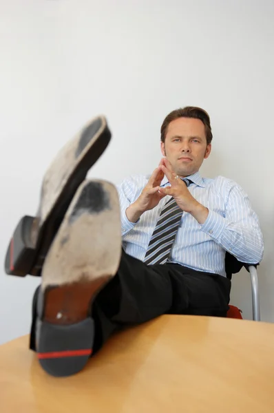 Homme d'affaires avec les pieds sur la table — Photo