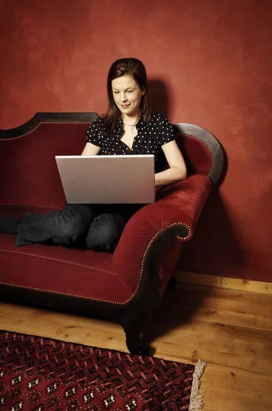 Vrouw op rode sofa serie — Stockfoto