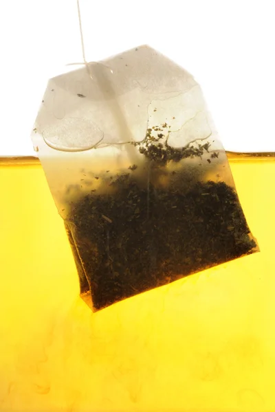 Peppermint Tea bag hanging into hot water — Stock Photo, Image