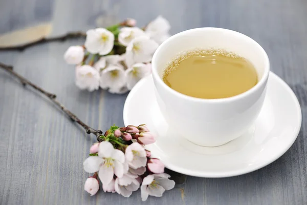 Xícara de chá verde e flor de cereja japonesa — Fotografia de Stock