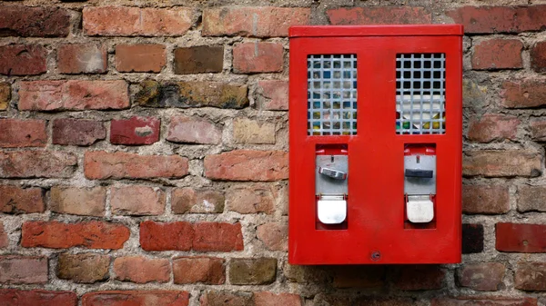 Rode gumbal, kauwgom machine opknoping op een oude muur — Stockfoto