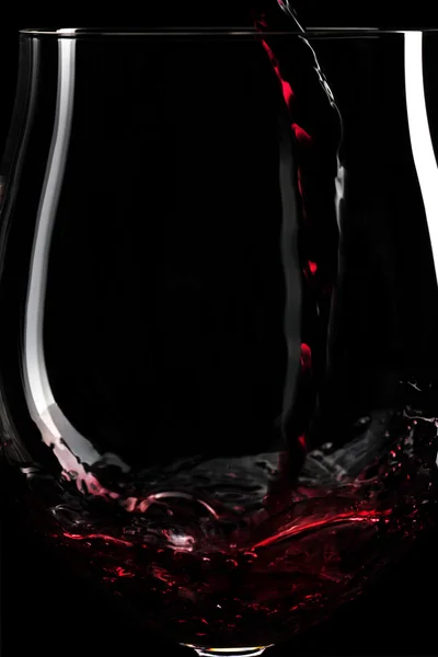 Close-up van rode wijn spatten in een glas — Stockfoto