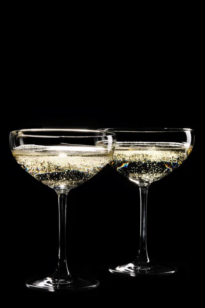 Twee glazen van sprankelende champagne infront van zwarte achtergrond — Stockfoto