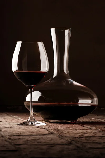 Vino rosso in decanter su pavimento in pietra rustica — Foto Stock