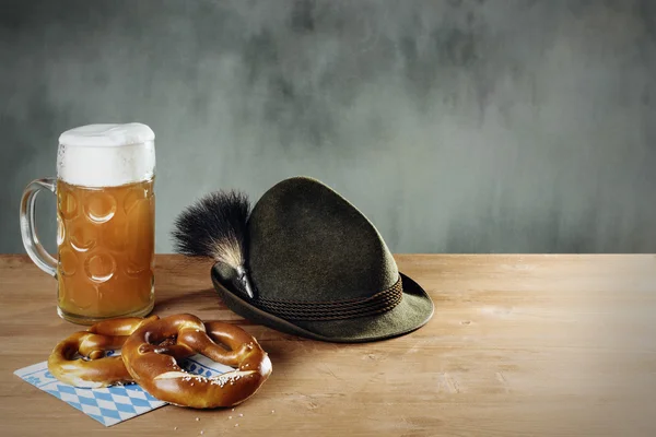 Masskrug öl, kringla och mössa med gamsbart — Stockfoto