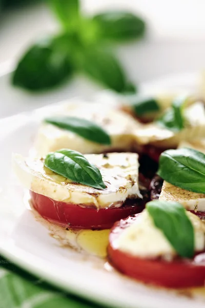 Fresh caprese salad with delicious tomatos, mozzarella and basil Stock Photo