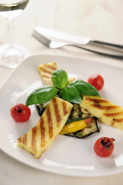 Queso Halloumi a la parrilla en verduras a la parrilla con albahaca Imagen De Stock