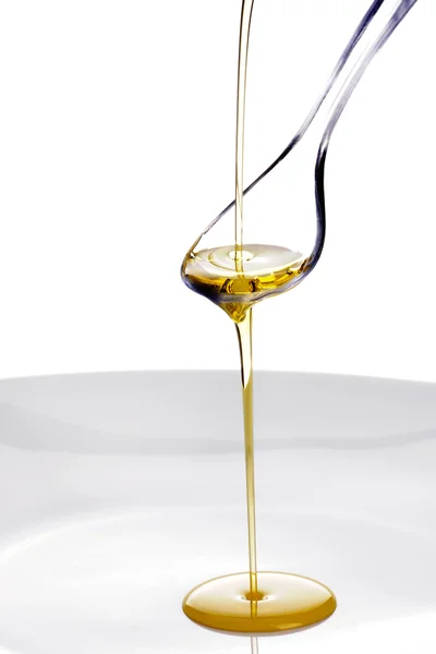 Olivolja hälls på en sked — Stockfoto