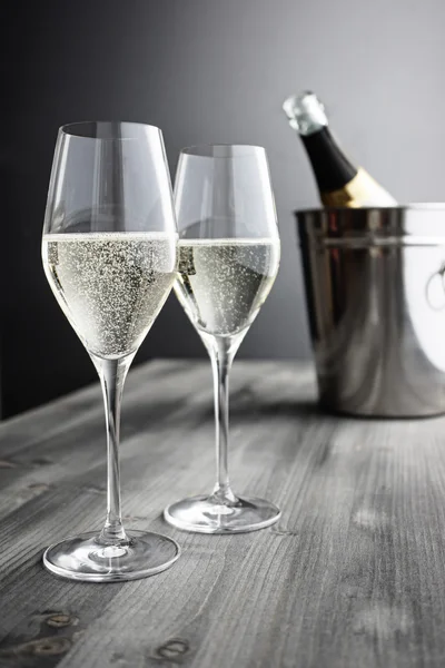 Twee glazen van champagne, fles en koeler Stockafbeelding