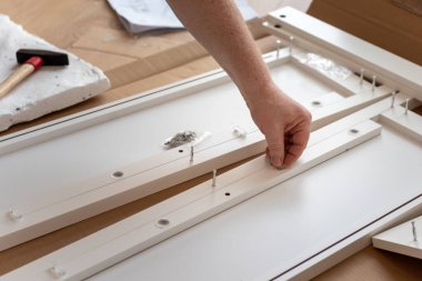 Adam yeni evinde mobilya montajı yapıyor.