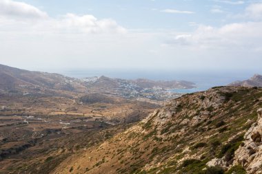 Ios Adası 'nın puslu batı kıyısının manzarası. Arka planda Chora kasabası ve limanı. Cyclades, Yunanistan