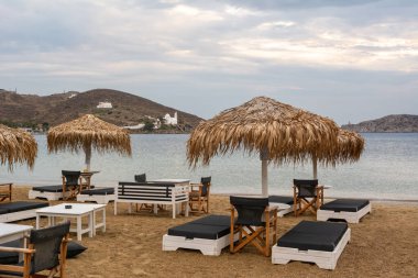 Ios, Yunanistan - 19 Eylül 2020: Ios Adası 'ndaki kumlu Chora plajında şemsiyeli plaj salonları. Cyclades, Yunanistan