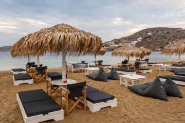 Ios, Yunanistan - 19 Eylül 2020: Ios Adası 'ndaki kumlu Chora plajında şemsiyeli plaj salonları. Cyclades, Yunanistan