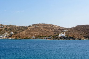 Yunanistan 'daki Ios Adası limanı, tepede küçük bir yerleşim yeri ve karakteristik bir kilise bulunan pitoresk bir koy. Cyclades Adaları, Yunanistan