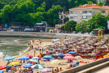 Ulcinj, Karadağ - 4 Haziran 2022: Ulcinj 'deki şehir plajında turistler. Ulcinj, Karadağ 'ın en güneydeki kenti..