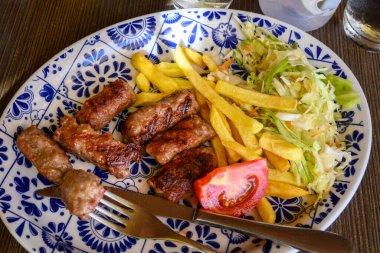 Cevapi, doğranmış domuz eti ve baharatlı sığır etinin küçük sosisleri olan Cevapici 'yi de çağırdı. Balkan ülkelerinde çok popüler bir yemek.
