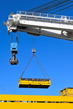 Yellow outdoor crane used in ship industry, electric overhead traveling crane above the vessel
