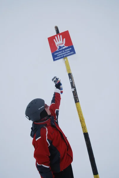 Nuvem no topo da montanha no Bansko búlgaro reduziu a visibilidade a zero atrás do sinal do perigo de avalanches — Fotografia de Stock