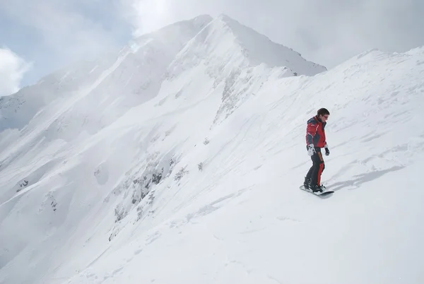 Snowboarder descend avec le sommet de la montagne à Bansko (Bulgarie) par une journée ensoleillée — Photo