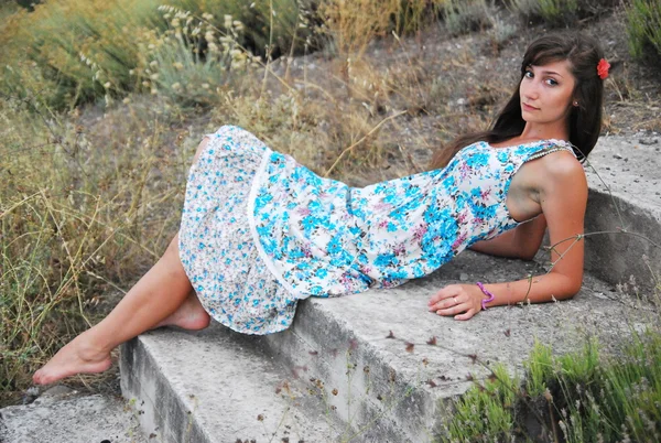 Girl with long dark hair in a long blue dress  on the beach — Stock Photo, Image