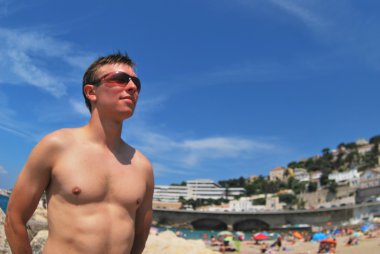 Marseille kumlu bir plaj üzerinde genç adam