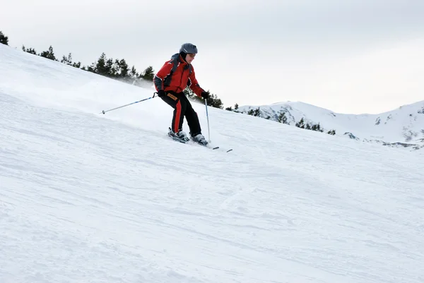 Jovem atleta esquiador descendo a encosta na estância de esqui de Bansko na Bulgária — Fotografia de Stock