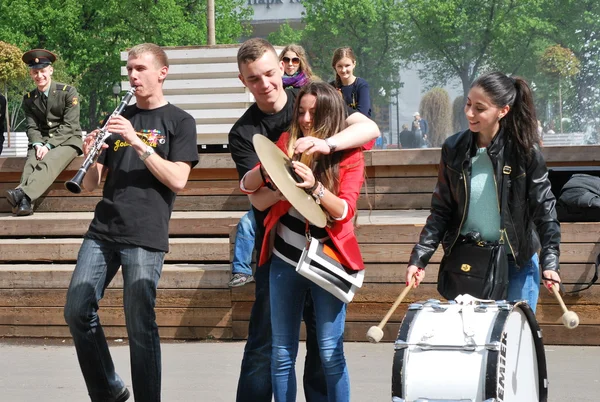 Jóvenes músicos callejeros enseñan a espectadores y transeúntes a tocar instrumentos musicales directamente en el Parque —  Fotos de Stock