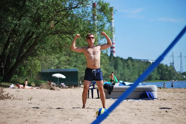 Ung man på stranden deltar i sport — Stockfoto