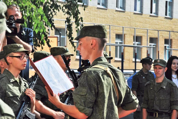 Man in een militair uniform ten tijde van de eed van dienst in de luchtmacht春の花： ミモザ、チューリップ、ムスカリ木製の背景に — Stockfoto