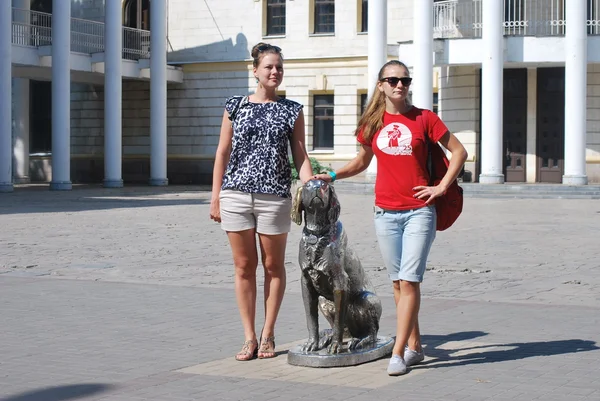Mädchen posiert mit dem Denkmal während eines Spaziergangs durch die Stadt — Stockfoto