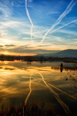 gün batımında gökyüzünde chemtrails Iseo Gölü manzarası