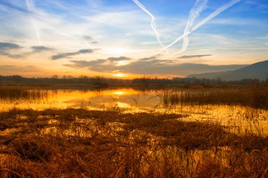 gün batımında gökyüzünde chemtrails Iseo Gölü manzarası
