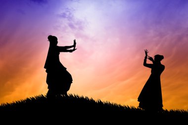 Gün batımında dans eden kadınlar