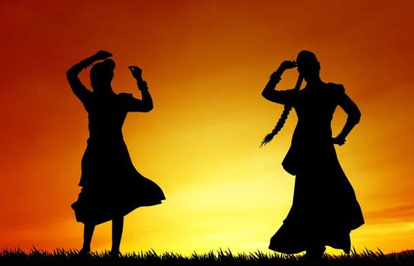 Women dancing indian dance at sunset — Stock Photo, Image