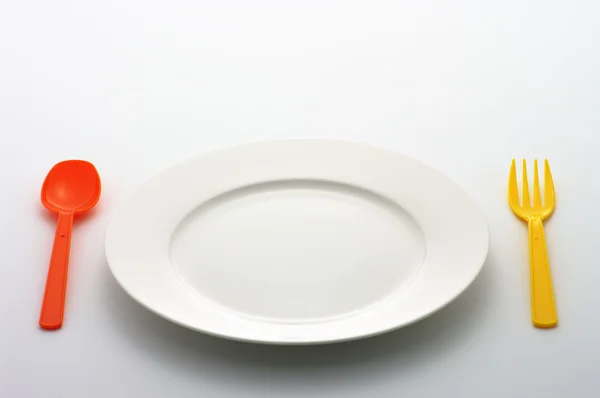 Yemek tabağı, renkli kaşık ve çatal — Stok fotoğraf