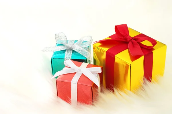 Red, gold and blue gifts on white fake fur background. — Stock Photo, Image