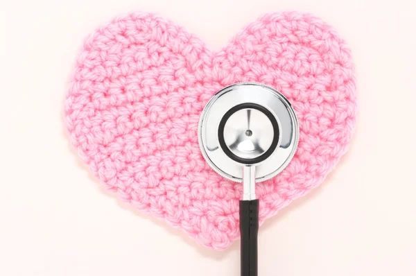 Stethoscope and pink knitted heart. — Stock Photo, Image