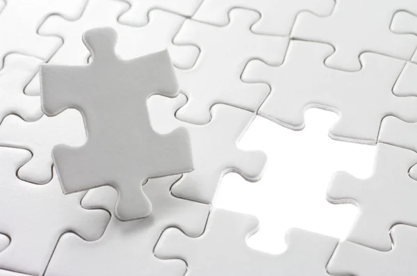 Unfinished jigsaw puzzle and last piece. — Stock Photo, Image