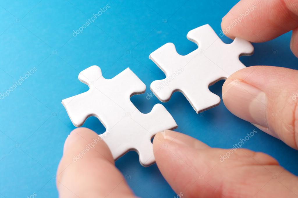 A person connecting puzzle pieces.