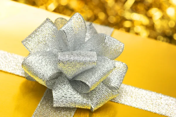 Gold-Geschenk mit silberner Schleife. — Stockfoto