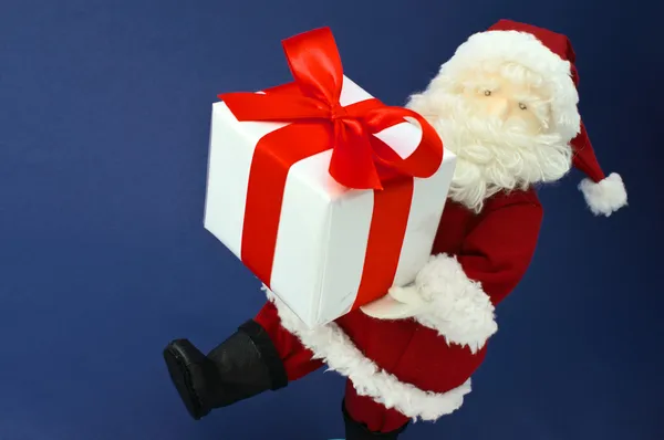 Cute stuffed toy Santa Claus hurrying with large Christmas prese — Stock Photo, Image