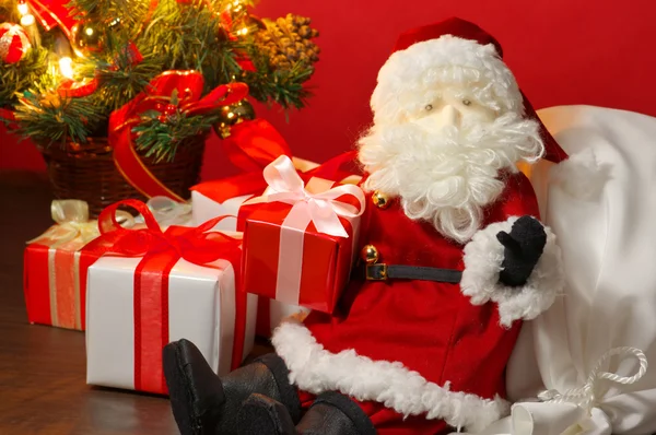 Stuffed toy Santa Claus and many Christmas presents. — Stock Photo, Image
