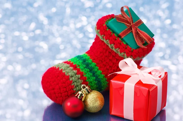 Kleine christmas stocking en presenteert op witte fonkeling pagina — Stockfoto