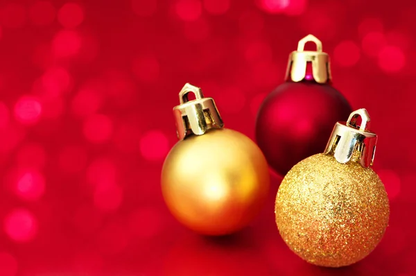 Kleine Weihnachtskugeln auf rotem Hintergrund. — Stockfoto