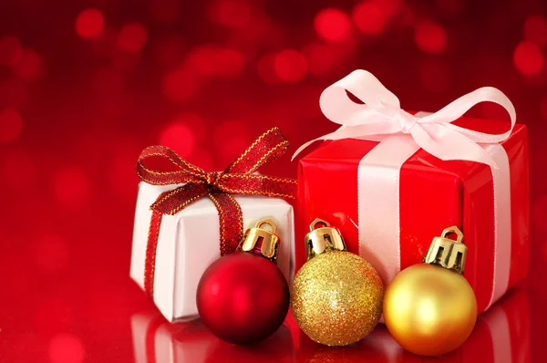Small presents on red sparkle background. Stock Picture
