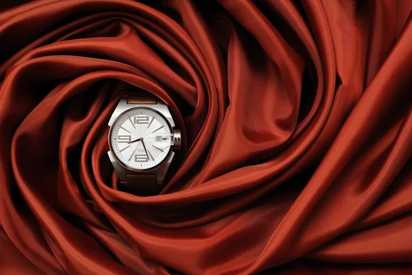 Un reloj de muñeca en un paño rojo — Foto de Stock