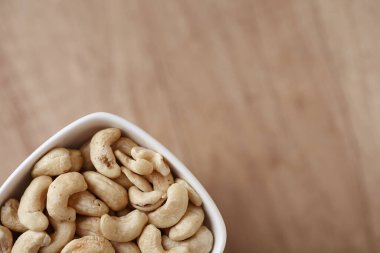 Ahşap bir masada kasede fındıklı fındıklar, üst manzara. Metin için boşluk