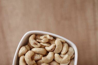 Ahşap bir masada kasede fındıklı fındıklar, üst manzara. Metin için boşluk